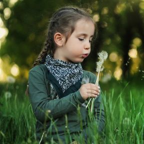 Child wishing on a dandelion 
